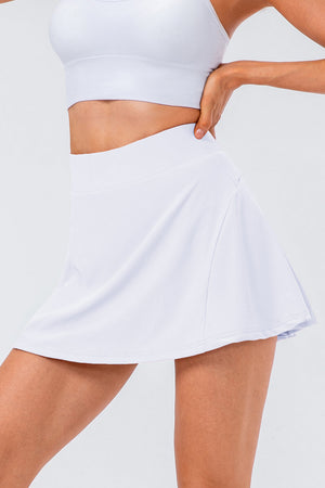 White performance pleated skort with a flared hem and subtle pocket detail.