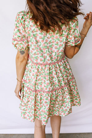 Women's tiered mini dress with floral print, puff sleeves, and pink trim detail.