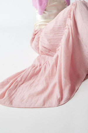 Tiered cotton maxi skirt in blush pink with ruffled details.