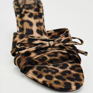 Leopard print knot heel mules with a bow detail.