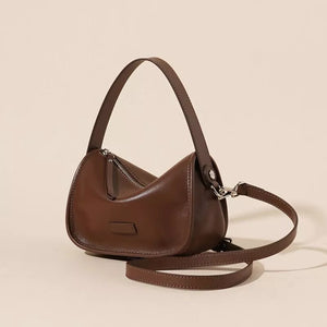 Caramel leather crossbody bag with adjustable straps and silver hardware.