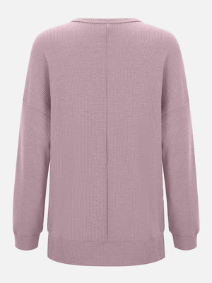 Dusty pink waffle knit crewneck top with relaxed fit and long sleeves.