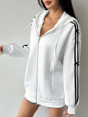 White zip-up hoodie with black stripes and bow details on sleeves.