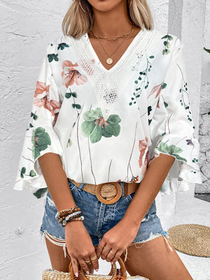 White floral bell sleeve blouse with lace trim neckline.