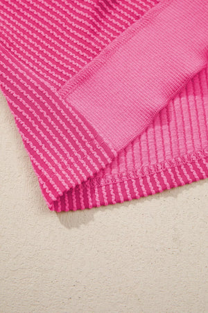 Pink ribbed maternity t-shirt with contrasting band detail and wavy hem.