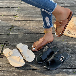 Chic toe loop flat sandals in black, beige, and brown with buckle detail.