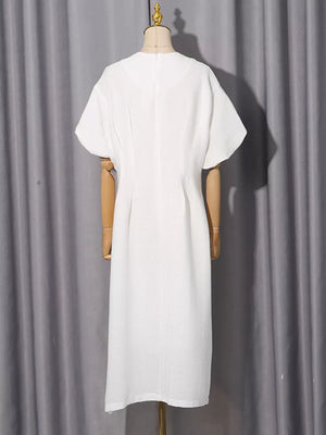 White midi dress with puff sleeves and a-line cut, featuring subtle texture and rhinestone embellishments.
