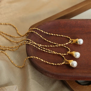 Gold pearl drop necklace with a bead chain and elegant pendant.
