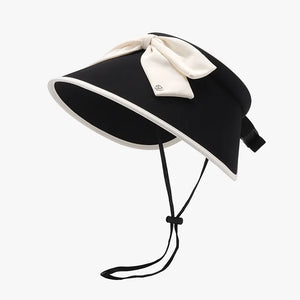 Black sun visor with ivory bow and contrast trim, adjustable chin strap.