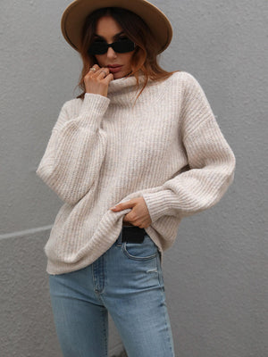 Voluminous turtleneck ribbed knit sweater in beige, featuring balloon sleeves and a relaxed fit.