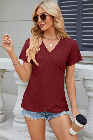 Burgundy eyelet wrap v-neck top with short sleeves and a textured pattern.