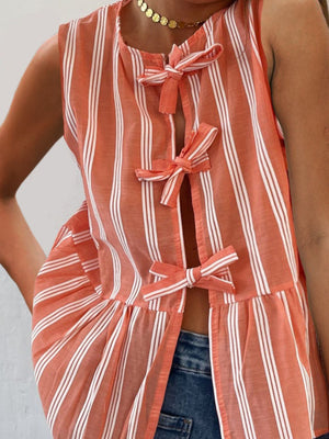 Orange and white striped peplum top with bow tie closures and a ruffled hem.