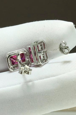 Emerald cut moissanite halo stud earrings in rose gold with diamond accents.