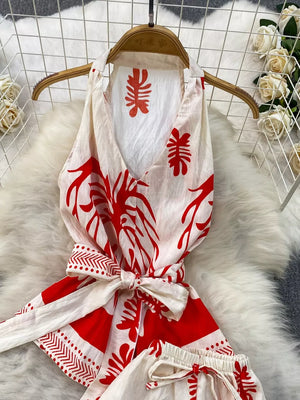 Tropical print two-piece set in red and white with belted detail and halter neckline.