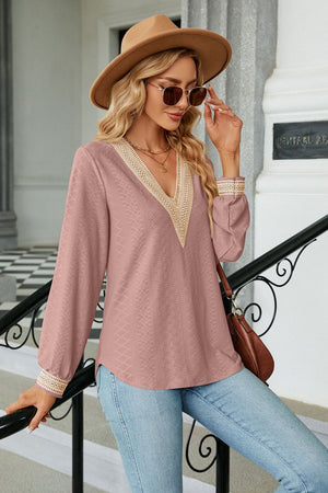 Pink textured V-neck blouse with embroidered trim and long sleeves