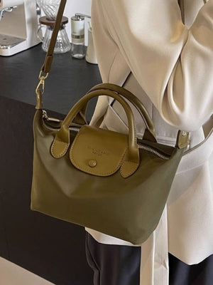 Green nylon crossbody bag with flap and top handles, casual style.