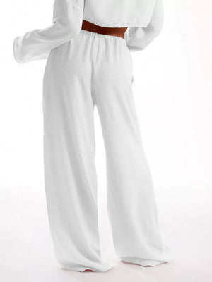 White relaxed wide-leg maternity pants with drawstring waist and textured fabric.
