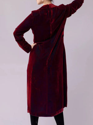 Burgundy velvet longline trench coat with draped detail.