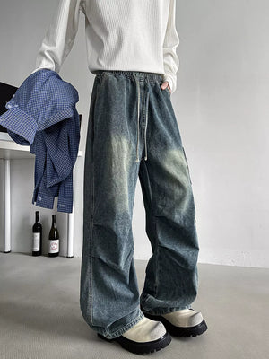 Relaxed fit blue denim cargo jeans with drawstring waist and distressed wash.