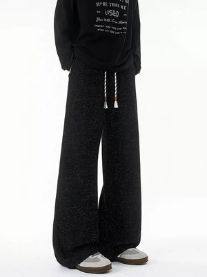 Black textured knit sweatpants with white drawstring and wide leg
