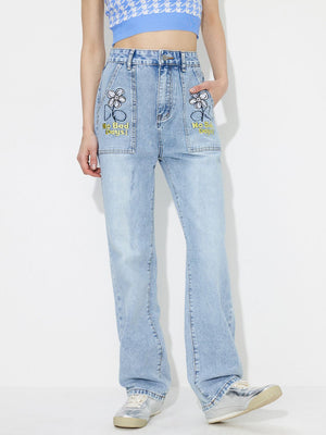 Light wash denim jeans with embroidered flower and "No Bad Days!" text on front pockets.