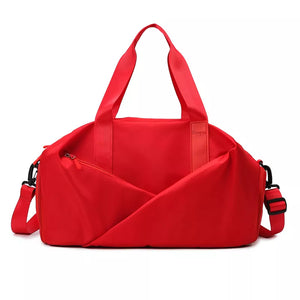 Red nylon travel bag with adjustable strap and zippered front pocket.
