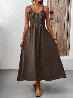 V-neck smocked midi dress in coffee brown with textured fabric and spaghetti straps.