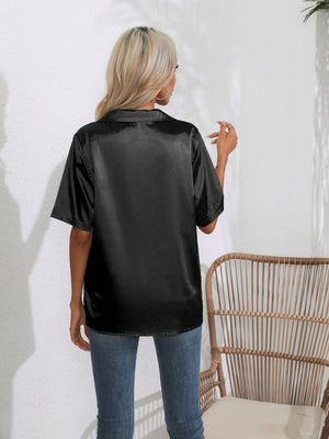 Black satin collared shirt with short sleeves, shown from the back.