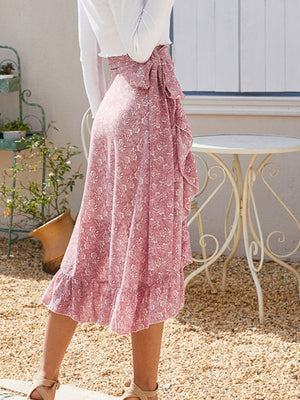 Asymmetric wrap skirt in Dusty Pink with a leaf print, ruffled hem, and tie waist.