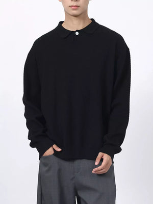 Men's black textured knit polo shirt with a classic collar and button closure.