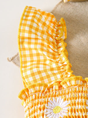 Yellow gingham baby one-piece with smocked bodice and daisy embroidery