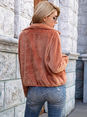Terracotta corduroy zip-up jacket with collar and pockets, styled casually.