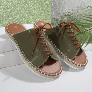Green open-toe flats with lace-up detail and espadrille sole.