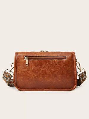 Tan leather crossbody bag with bohemian patterned strap and zip pocket