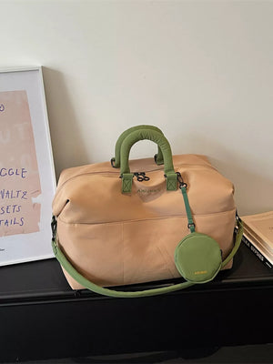 Two-tone nylon duffle bag in camel with green handles and strap, includes detachable pouch.