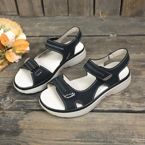Black platform sandals with contrast white stitching and adjustable straps.