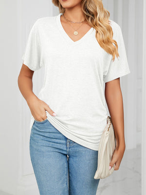 Relaxed white v-neck short sleeve t-shirt with a draping fit, styled with jeans and a clutch.