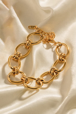 Chunky gold knot link bracelet with adjustable clasp and 18K gold plating.