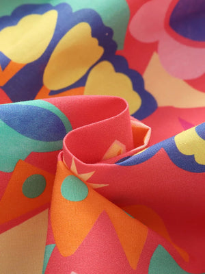Toddler dress fabric with vibrant floral print in pink, yellow, blue, and orange.