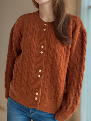 Caramel cable knit cardigan with puff sleeves and gold buttons.