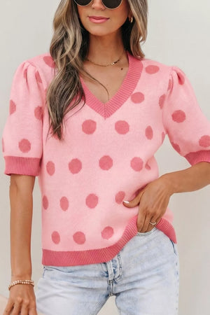 Pink polka dot knit top with V-neck, puff sleeves, and contrast trim.
