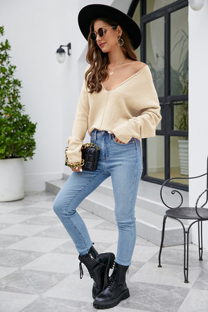 Caramel fluffy knit sweater with plunging neckline and long sleeves, styled with jeans.