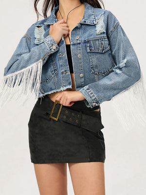Distressed denim trucker jacket with fringe trim and frayed hem.