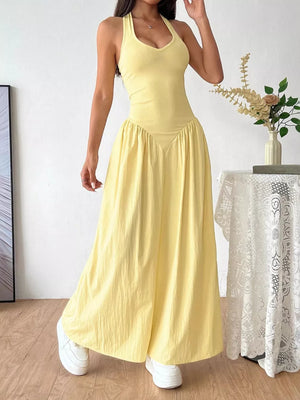 Yellow V-neck ruched maxi dress with empire waist and halter neckline.
