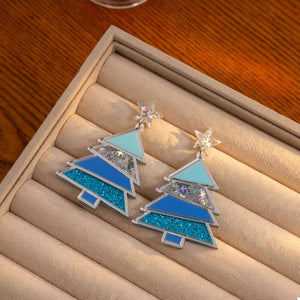 Whimsical Christmas tree dangle earrings in blue acrylic with glitter and confetti details.
