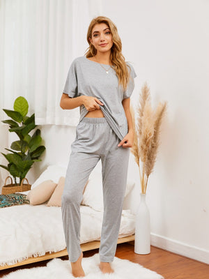 Gray loungewear set with asymmetric neckline top and relaxed fit pants.