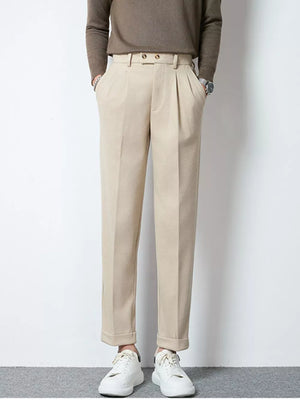 Men's khaki pleated dress pants with cuffed hems and double button closure.