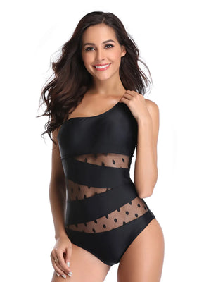 Black one-shoulder swimsuit with sheer polka dot mesh insets and diagonal straps.