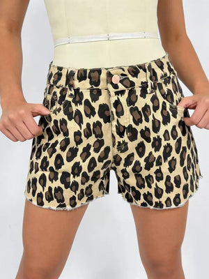 Leopard print high-waisted denim shorts with raw hem and button fly.