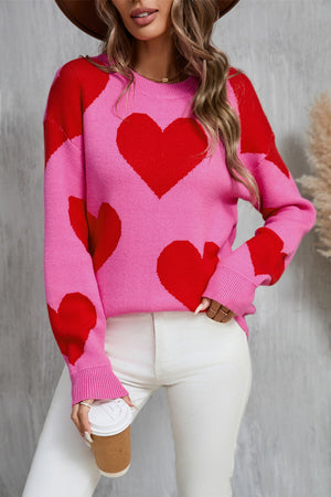 Pink and red heart patchwork knit sweater with crew neck and long sleeves.